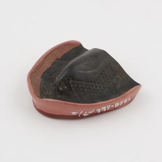 Dark brown vulcanite denture plate with pink rim