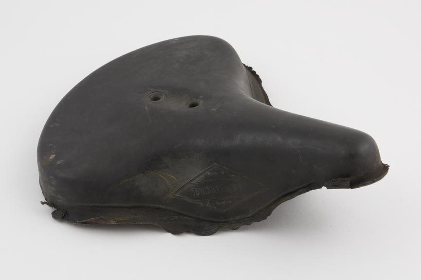 Black rubber bicycle saddle, made by Dunlop, England