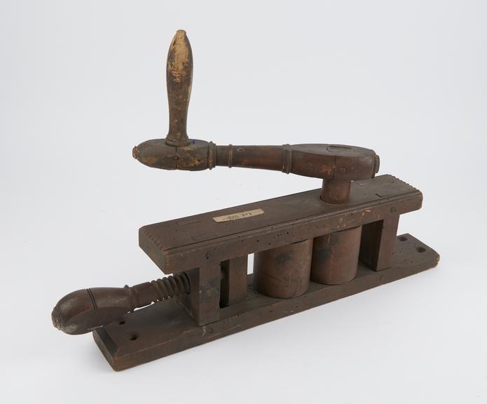 Wooden press with two rollers revolved by turning handle