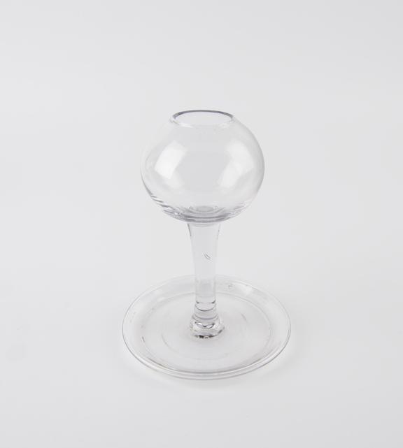 One of pair of early glass lamps with plain globular bowls on