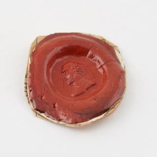 Oval seal with red stamp showing Shakespeare's head