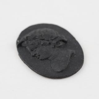 Medallion of black Parkesine, male head
