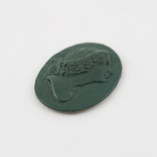 Medallion of green Parkesine, female head