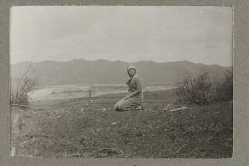 Untitled black and white photograph showing H. I. H. The Grand Duchess Olga Alexandrovna kneeling by the river Bzib