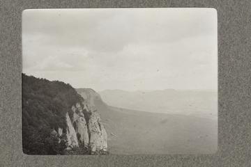 Untitled black and white photograph showing a mountainous view with tree covered