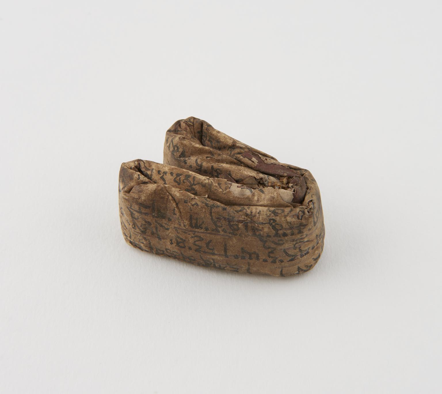 Charm, andwritten on reed which is now tightly folded into fragile ...