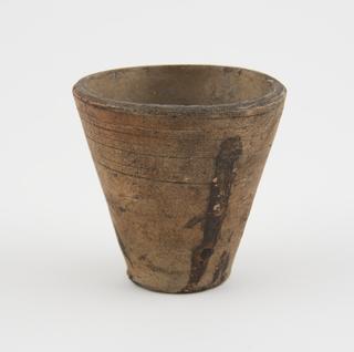 Thick roughly glazed earthenware dispensing pot