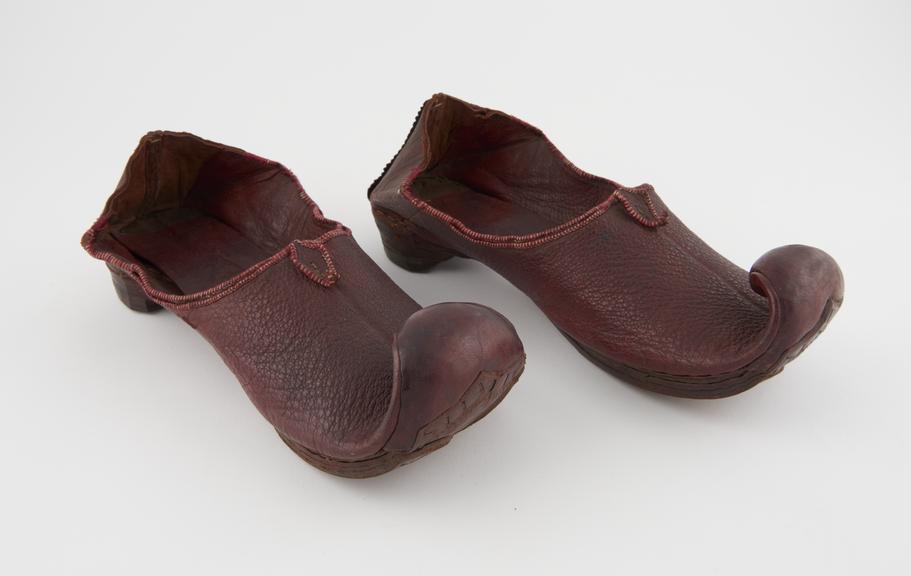 Pair of red leather slippers with upturned pointed toes