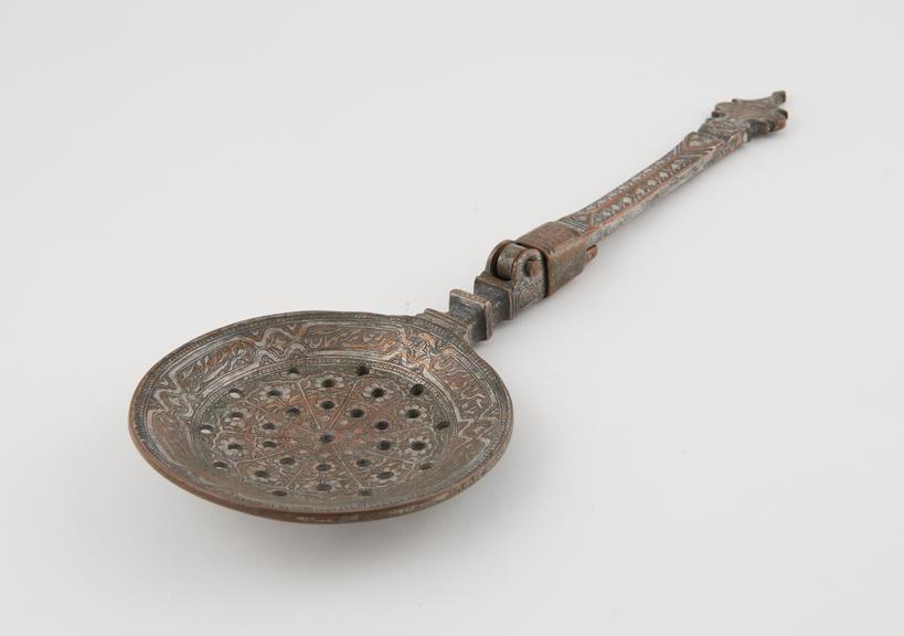 Steel spoon with shallow perforated bowl and tinged handle