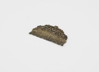 Short close toothed gilt comb with leaf and bird design