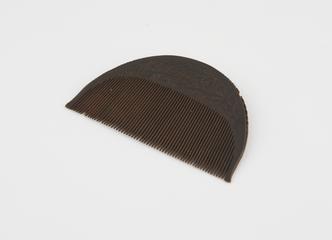 Carved wooden comb with decorated crescent-shaped handle carved with Islamic script