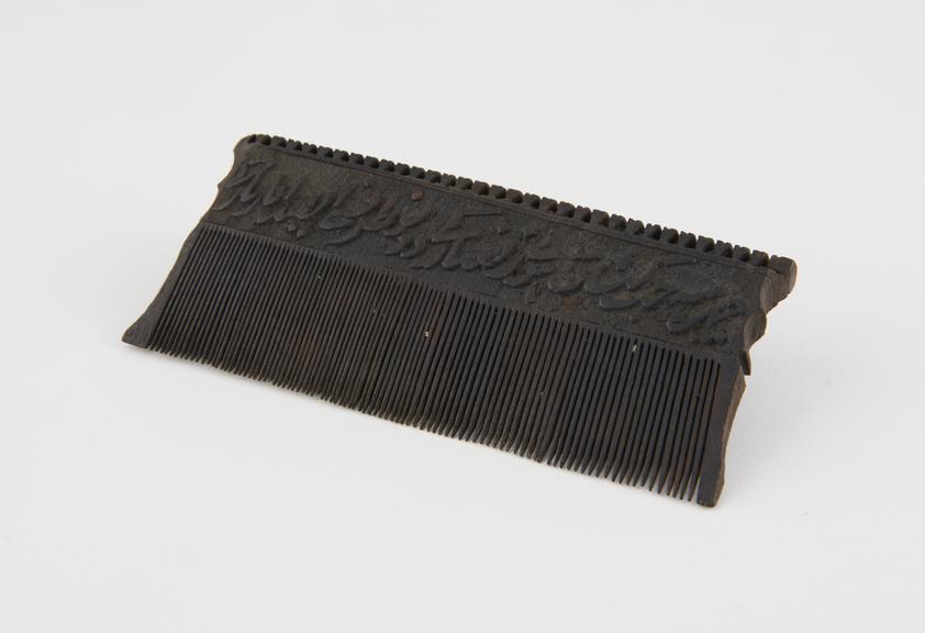 Black wooden close-toothed comb with serrated top