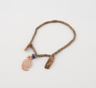 Bracelet of small polished stone beads with carved central pendant