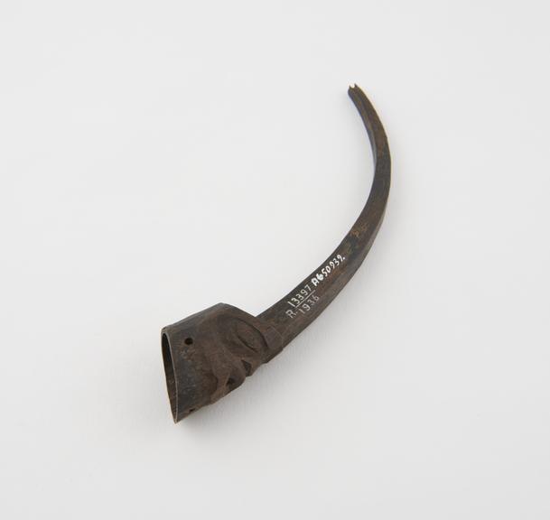 Carved mountain goat horn human head with long spur rising from