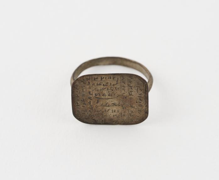 Metalfinger ring with rectangular bezzel bearing an inscription