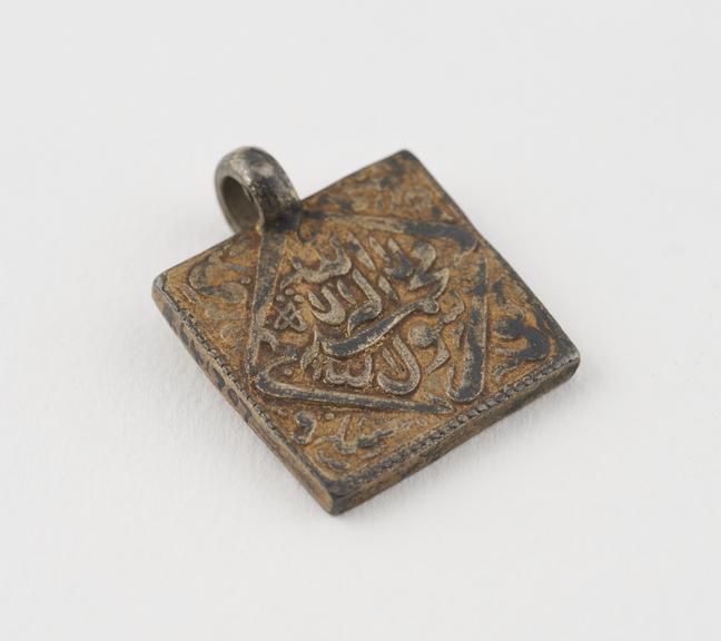 Metal square, bearing an inscription, possibly Arabic