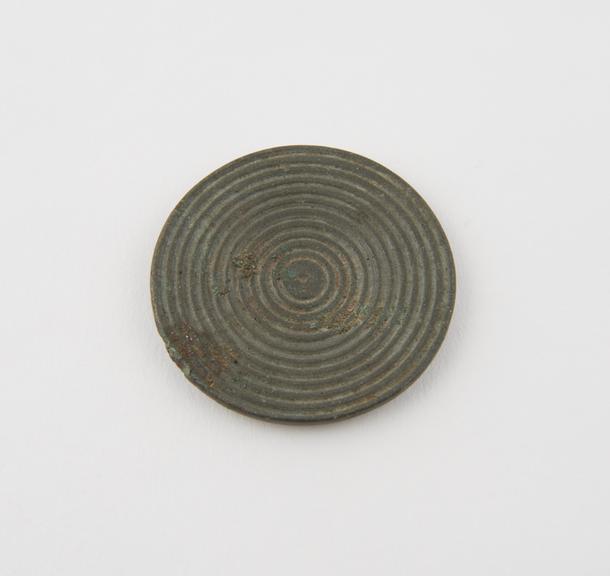 Bronze(?) disc, obverse covered with concentric grooved circles