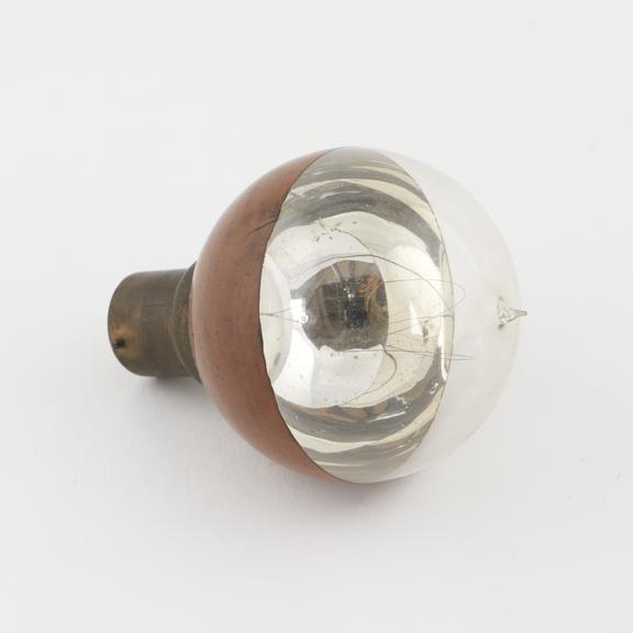 Early lamp with half-mirrored bulb.