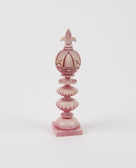 A King, one of sixteen ivory chessmen, covered with a pink wash