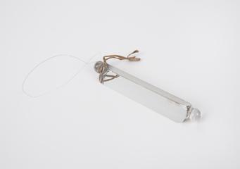 Glass prism (length: 16.5cm.) with lugs (for mounting in frame)