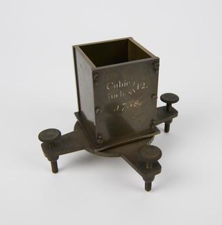 One of four rectangular bronze cubic measures for 12 cubic inches with square glass strike