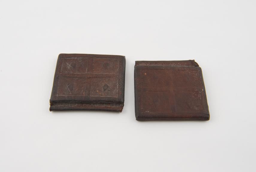 Two identical leather amulet cases, square, flat, solid