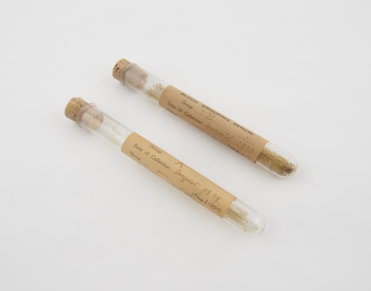 Blood grouping sera in two test tubes with a container of silk