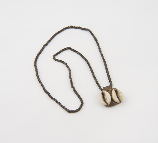 Amuletic necklace comprising two cowrie shells sewn onto a