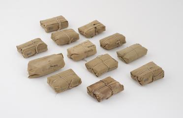 12 khaki packages each containing a dressing with bandage attached