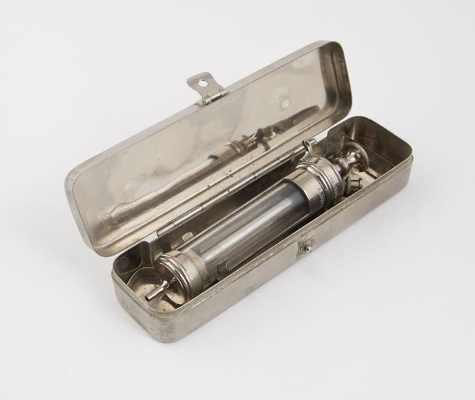 Hypodermic syringe, glass and nickel plated brass, by Burroughs