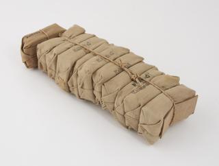 11 packages of cloth tied with string containing bandages with attached dressings