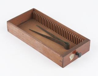 Drawer containing pair of tweezers