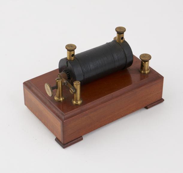 Small induction coil mounted on small wooden base