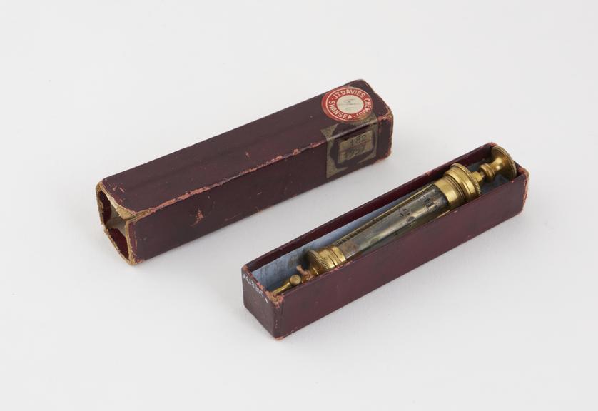 Aspirating syringe, glass and gilt metal, in cardboard box