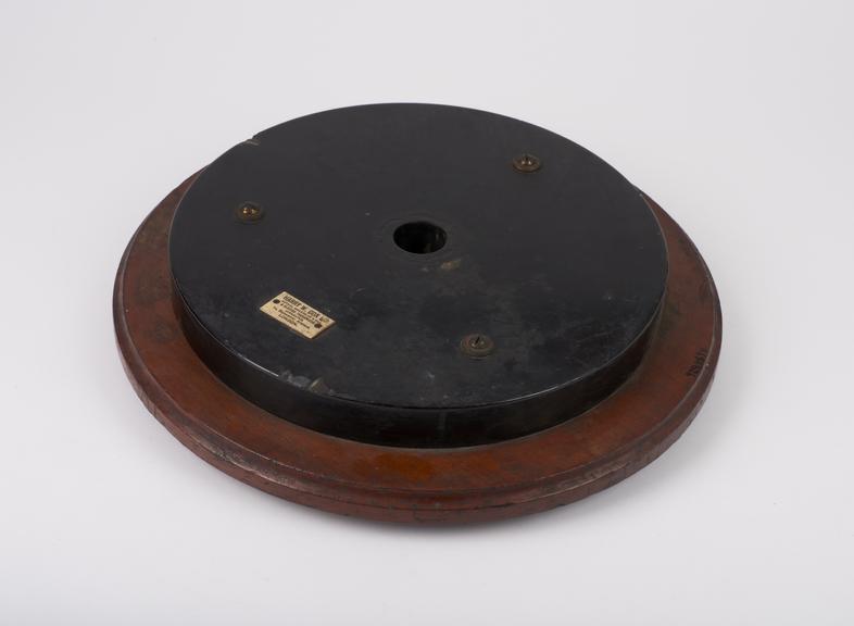 Circular wooden and vulcanite stand with central hole