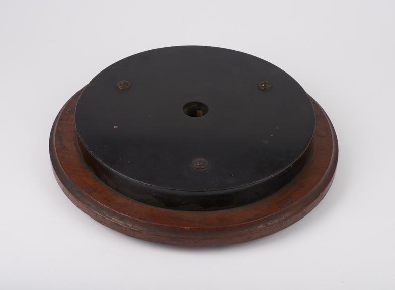 Circular wooden and vulcanite stand with central hole