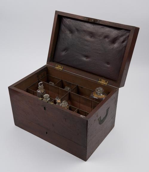 Mahogany medicine chest with 10 empty glass bottles with