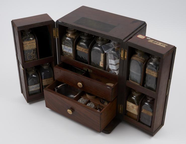 Medicine chest, tryptich front with 17 glass bottles mostly