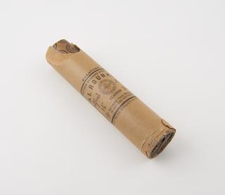 Cylindrical stick of explosive substitute in cream paper wrapper with black printing over cardboard tube