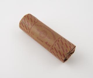 Cylindrical stick of explosive substitute in brown paper wrapper with red printing and red parallelogram pattern