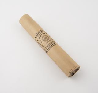 Cylindrical stick of explosive substitute in cream paper wrapper with black printing