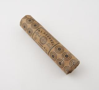 Cylindrical stick of explosive substitute in cream paper wrapper with black printing and black roundel patterning
