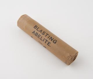 Cylindrical stick of explosive substitute in brown paper wrapper, printed: ‘BLASTING’; ‘ABELITE';