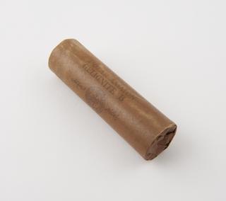 Cylindrical stick of explosive substitute in brown waxed paper wrapper, printed: ‘POLAR AMMON’; ‘GELIGNITE B’