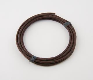Coil of brown gutta-percha covered dummy burning fuze
