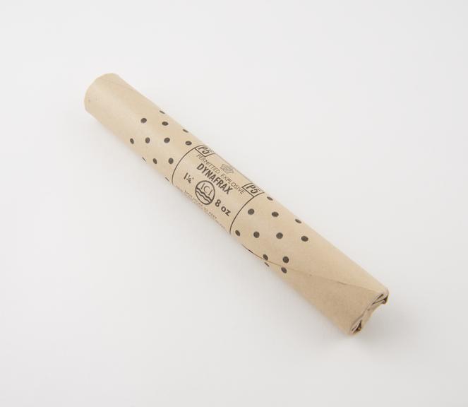 Cylindrical stick of explosive substitute in white waxed paper