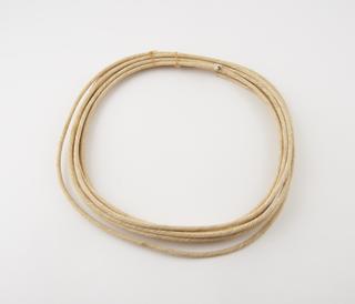 Coil of white cotton covered dummy burning fuze