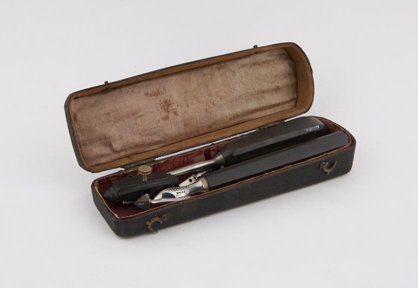 Rectangular black fish-skin instrument case containing five