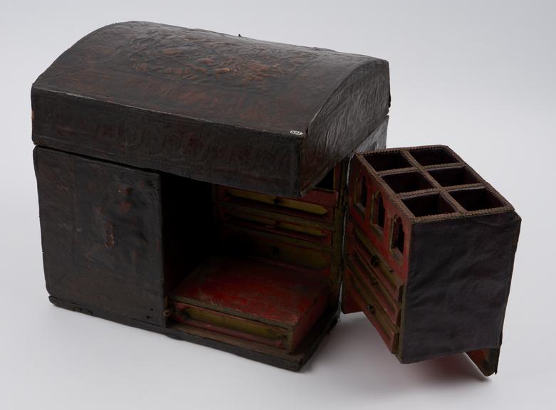 Leather covered medicine chest with embosed panels of bottle