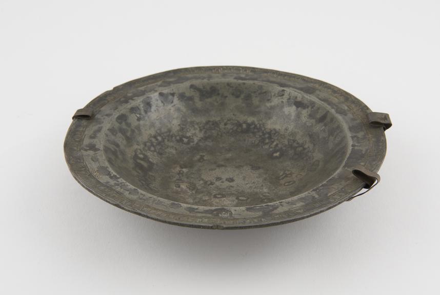 Pewter dish, with tonge patterned border and initials N.C